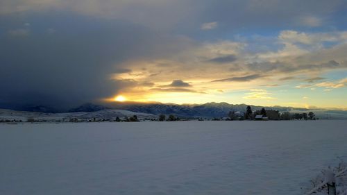 Scenic view of snow covered landscape against cloudy sky