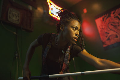 A young woman playing pool.