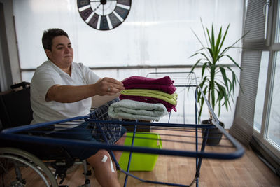 A disabled person on a wheelchair washes laundry