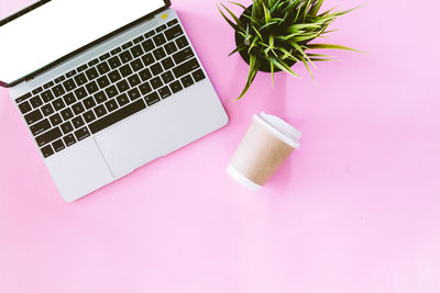 High angle view of laptop by potted plant on table