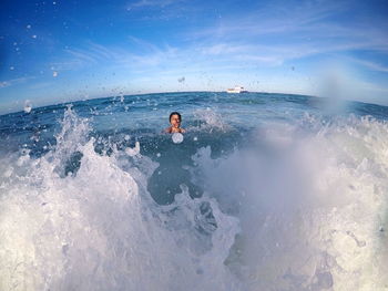 Man surfing in sea against sky