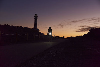 Young cyclist riding bicycle on road at sunrise