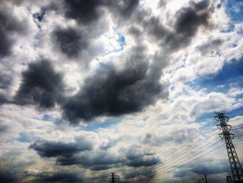 Low angle view of cables against cloudy sky