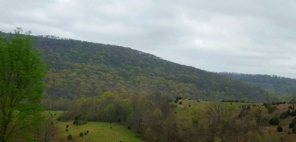 Scenic view of mountains against cloudy sky