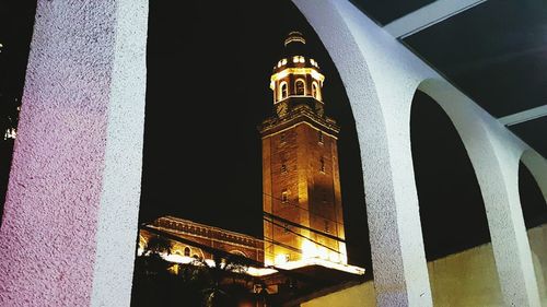 Low angle view of clock tower at night