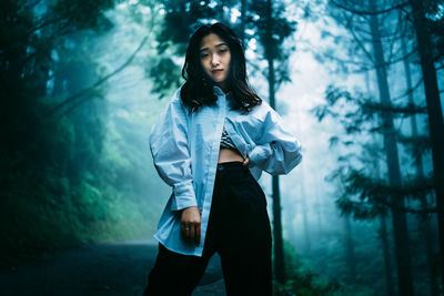 Young woman standing in forest