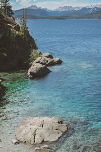 Rock formation in sea against sky