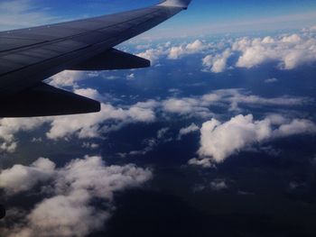 Cropped image of airplane flying over cloudy sky