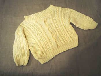 High angle view of yellow sweater on bed