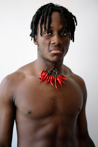 Portrait of shirtless man standing against white background