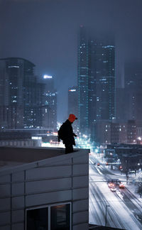 Rear view of woman standing in city at night