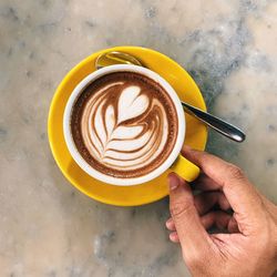 High angle view of hand holding coffee cup