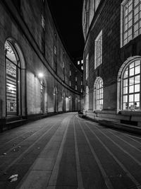 Empty road along buildings at night