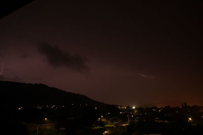 Illuminated city against sky at night