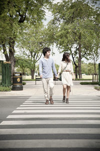 Full length of couple crossing road