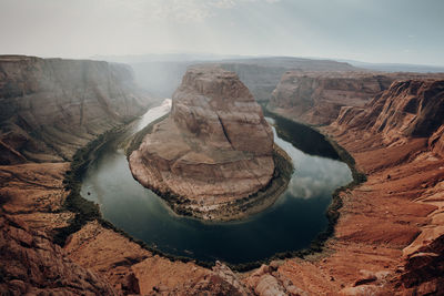 Aerial view of river and rock formations against sky