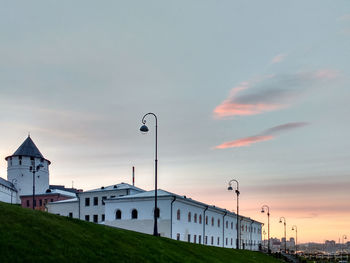 Street and buildings against sky during sunset