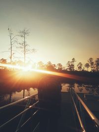 Cars on road against sky during sunset