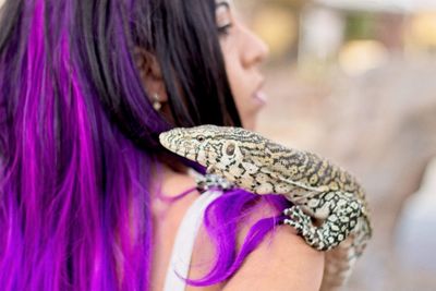 Close up monitor lizard on women's shoulder 