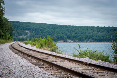 Railroad track by trees against sky