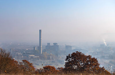 Smoke emitting from chimney against sky