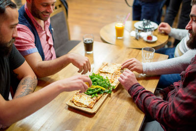 Happy friends having food at table