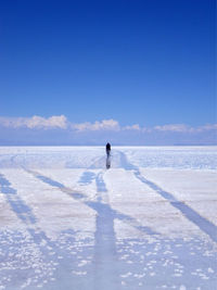 Man on riding bicycle on salt flat at salar de uyuni