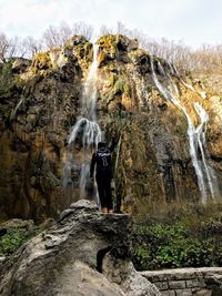 Rear view of man standing on rock