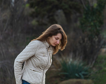 Woman standing by tree