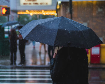 Rear view of woman holding umbrella