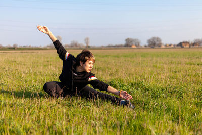 Caucasian young woman practicing wushu martial art in a green meadow