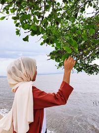 Rear view of woman overlooking calm sea