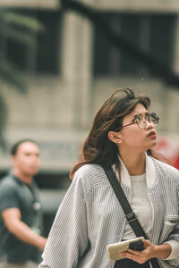 Female friends looking at camera while standing against blurred background