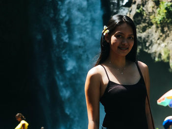 Portrait of smiling young woman standing outdoors