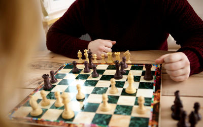 Close-up of men playing on chess at table