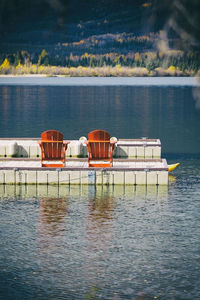 Red chairs on the jetty of a lake, canadas