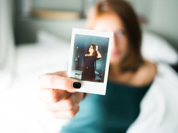 Midsection of woman photographing with mobile phone