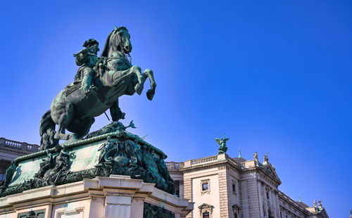 Low angle view of statue against blue sky