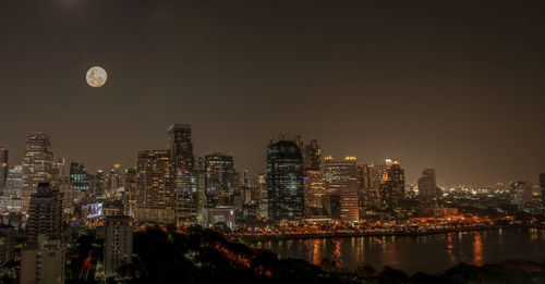 Illuminated buildings in city against sky at night