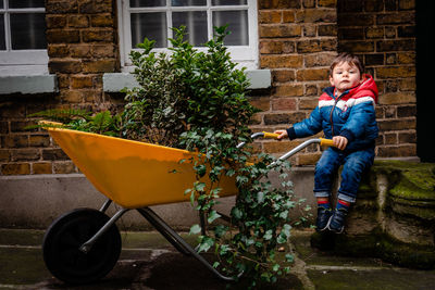 Portrait of boy holding umbrella in yard