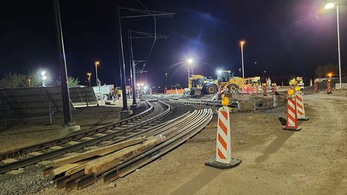 Illuminated street lights on railroad tracks at night