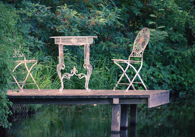 Text on chair against plants in park