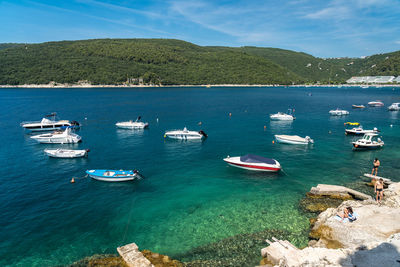 High angle view of sailboats moored on sea against sky