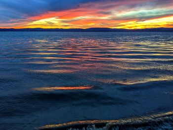 Scenic view of sea against dramatic sky during sunset
