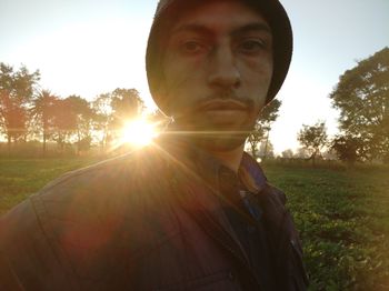 Portrait of man on field against sky during sunset