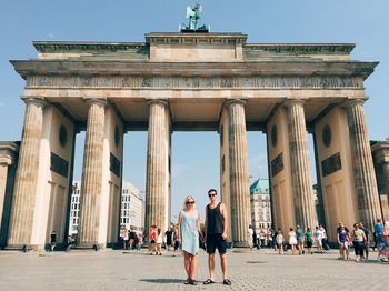 Portrait of friend standing against brandenburg gate