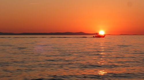 Scenic view of sea against orange sky during sunset