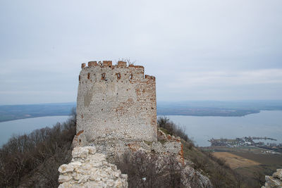 Old fort by sea against sky