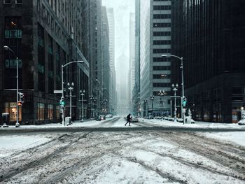 Street amidst buildings in city during winter