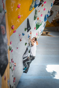 Full length of man climbing wall